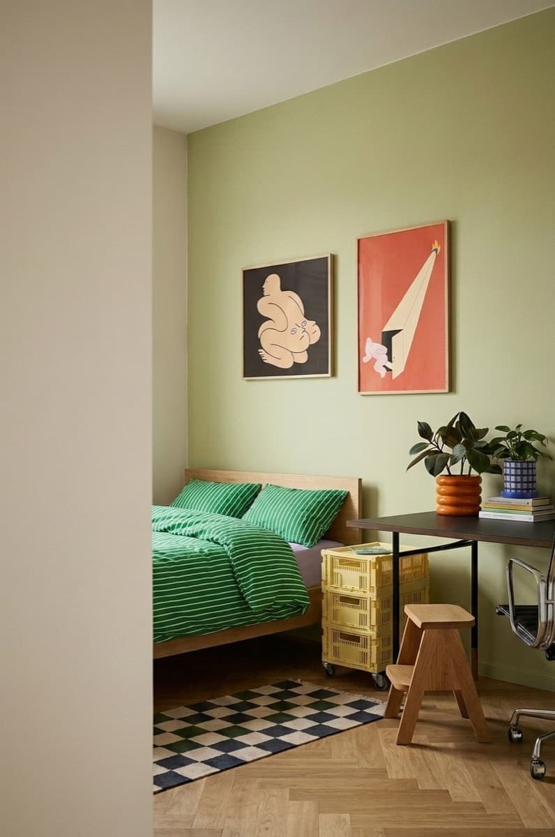 A pair of framed Scandinavian prints on the wall above a bed