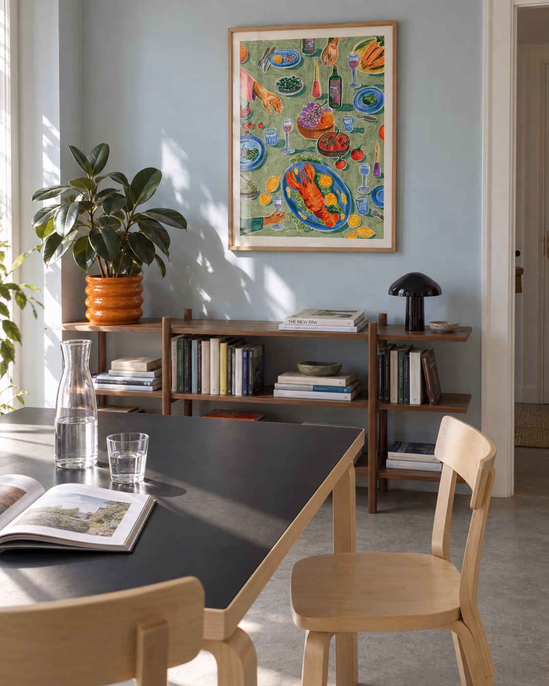 Hummer og Vin by Sia Siamos framed above a dining table in a blue room