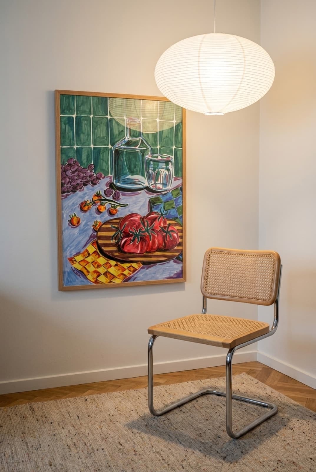 Hyttefrokost by Sia Siamos framed in oak on a warm white wall, above a cane chair under a paper pendant
